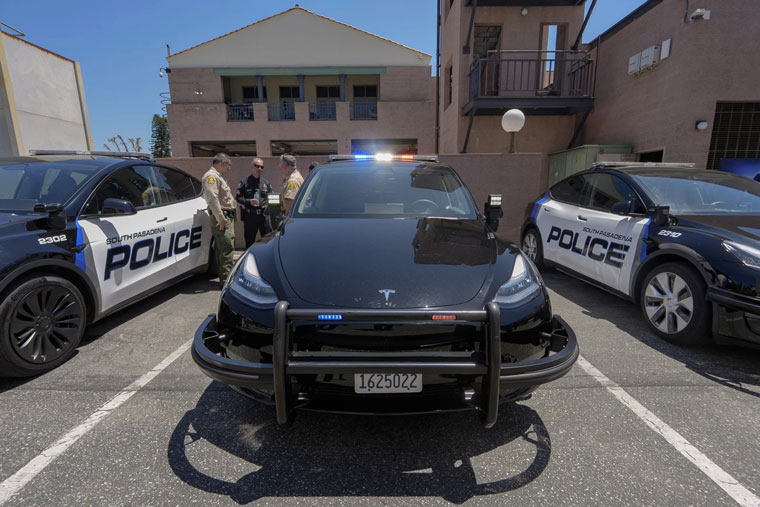 South Pasadena Police Department EV Project Lead, Sergeant Tony Abdalla, middle, shows Los Angeles County Sheriff's fleet managers, Capt. David Sum, left, and Lt. Robert Furman, as South Pasadena Police Department unveils its zero-emission police fleet of 20 Teslas Monday, July 29, 2024, in South Pasadena, Calif. (AP Photo/Damian Dovarganes)